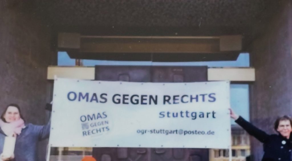 Zwei Teilnehmerinnen halten Tratransparent der Omas gegen Rechts vor dem Stuttgarter Rathaus